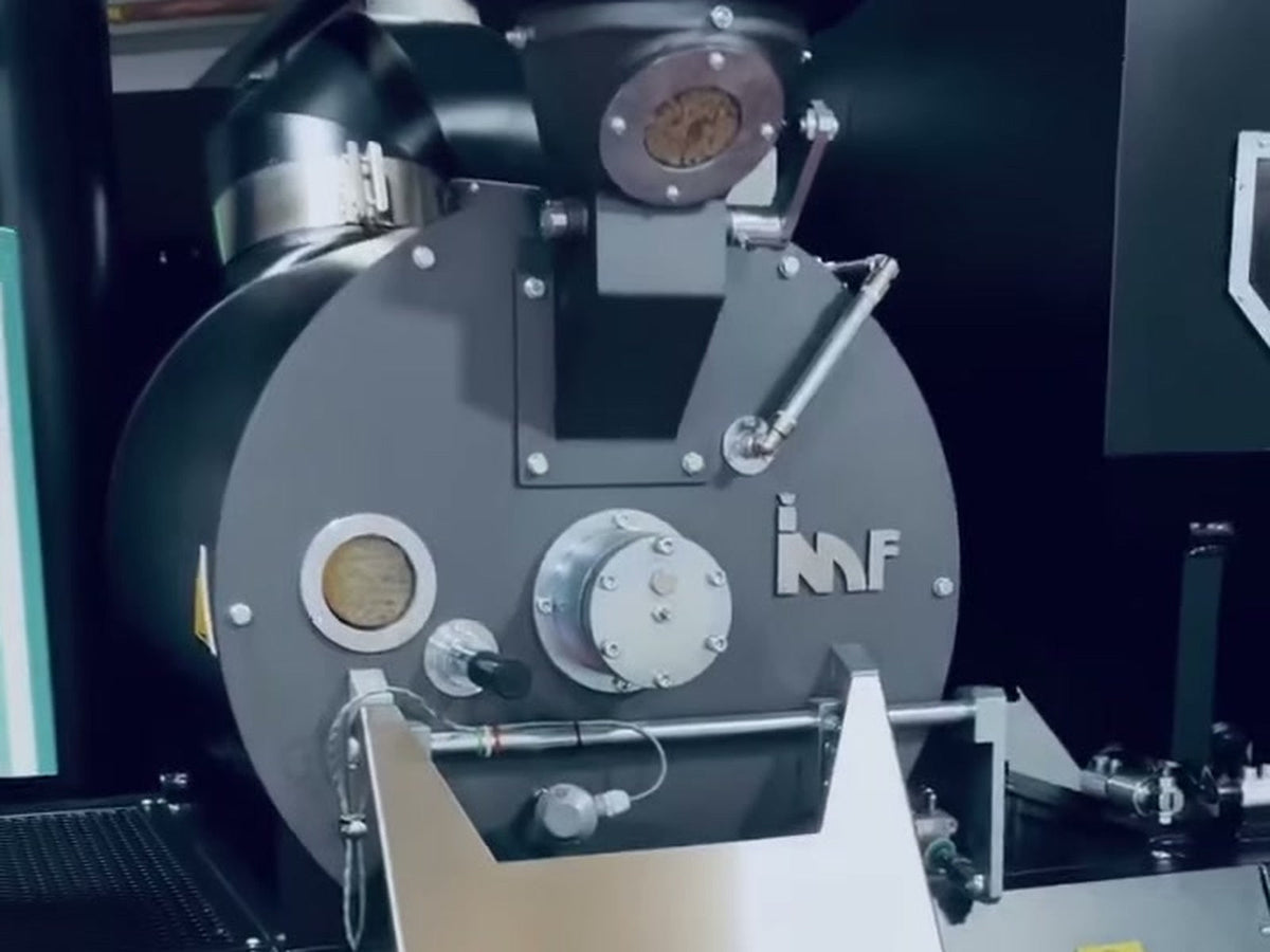 Detail of an IMF coffee roaster with its inspection window and maker badge.